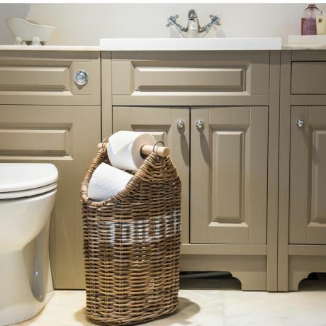 Steinfarbenes Badezimmer mit Waschbeckenunterschrank und Korbrollenhalter