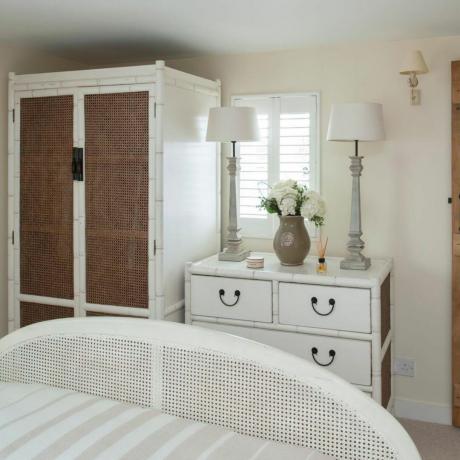 Вінтажна шафа в колоніальному стилі з плетеними дверцятами, бамбуковим комодом, дерев'яними дверцятами з ручкою. Будинок, що належить Холлі та Крісу Леветтам,