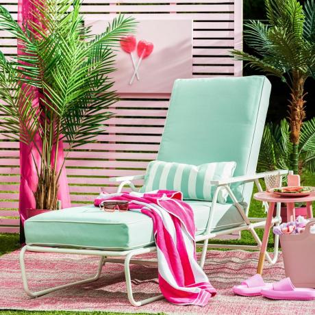 nyugágy szabadtéri szőnyegen rózsaszín kerítéssel és kerti bútorokkal