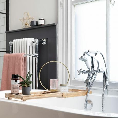 Monokromt badrum med fristående badkar, traditionella kromkranar, bambubadkar, väggpaneler och viktoriansk radiator