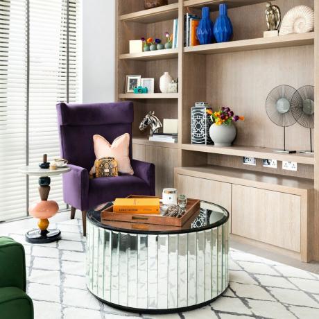 Obývací pokoj s vestavěným dřevěným úložným prostorem a kulatým zrcadlovým konferenčním stolkem