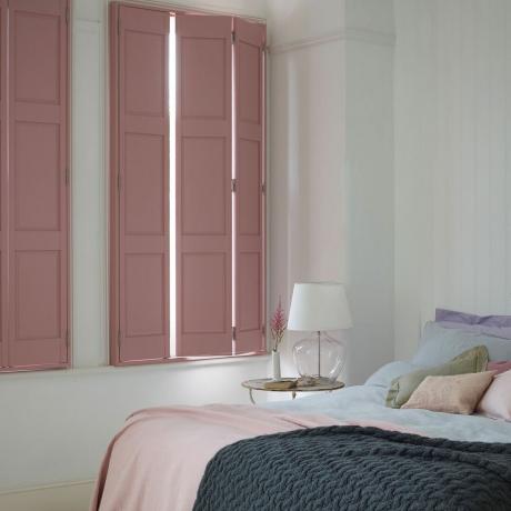 współczesna sypialnia z różowymi, solidnymi okiennicami