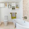 Reforma do banheiro branco com banheira separada e painel de azulejos