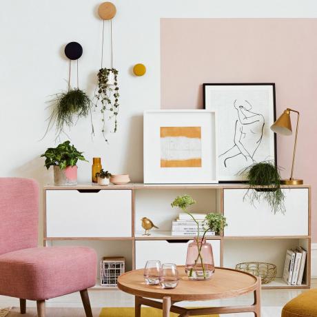 Salón rosa con silla rosa y mueble multimedia