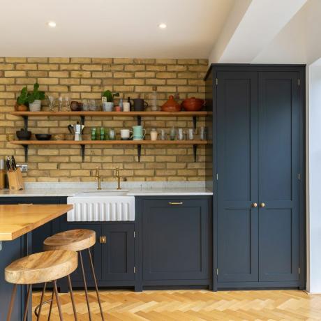 visualizzare in una cucina e isola cucina con un muro di mattoni a vista