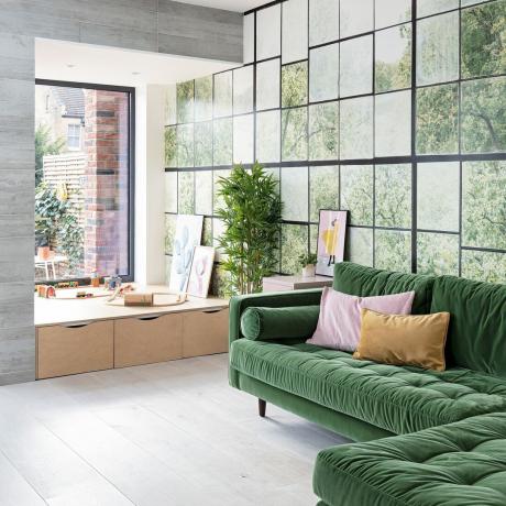 Moderní obývací prostor se zelenou sametovou pohovkou ve tvaru L, nástěnnou stěnou ve stylu okna a elegantními šedými stěnami a podlahami