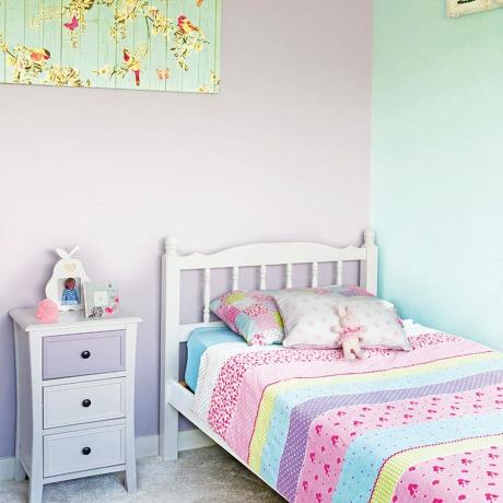 Traditionellt rosa litet flickas sovrum med vitmålade möbler