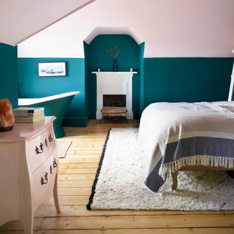 ห้องนอนสีชมพูและสีน้านพร้อมเตาผิงและอ่างอาบน้ำลอยตัว