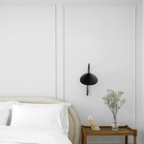 غرفة نوم بيضاء مع لوحة جدارية مميزة