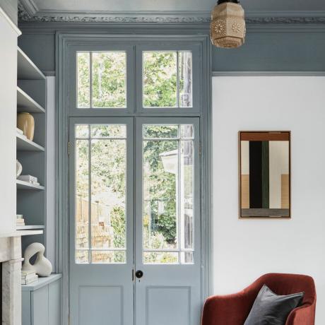 Idei de tavan pentru sufragerie, living cu lemn gri albastru, pereți și tavan, pandantiv vintage, fotoliu ruginit, oglindă, rafturi, vedere în exterior prin uși franceze
