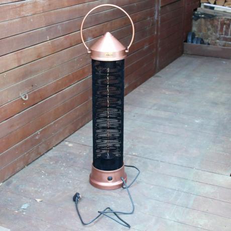 Încălzitorul de terasă cu felinar de cupru Kettler Kalos este testat pe pardoseală din lemn