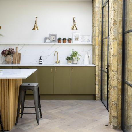 virtuvė su marmuriniais stalviršiais ir žalvariniais sieniniais šviestuvais